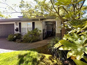 A house with a garage, a stone pathway, and a well-maintained lawn. - Crescent House - Tranquil Downtown Home (Lodi)