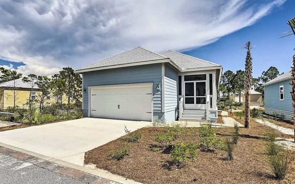 A single-story house with a garage, a front porch, and a landscaped yard.