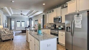 A spacious kitchen with granite countertops, stainless steel appliances, and light-colored cabinetry. - Ocean View  (Phoenix)