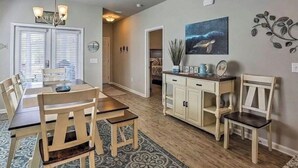 A dining area with a wooden table and chairs, a chandelier, and a painting on the wall. - Ocean View  (Phoenix)