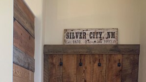 Maalaishenkinen puinen penkki, jonka yläpuolella on kyltti, jossa lukee: ”SILVER CITY, NM, perustettu 1870, merenpinnan korkeus 5995 jalkaa.”