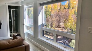 A hallway with large windows offering a view of autumn foliage. - Ski-Access and View Chair 5 Runs From Cabin in Brian Head, UT (Brian Head)