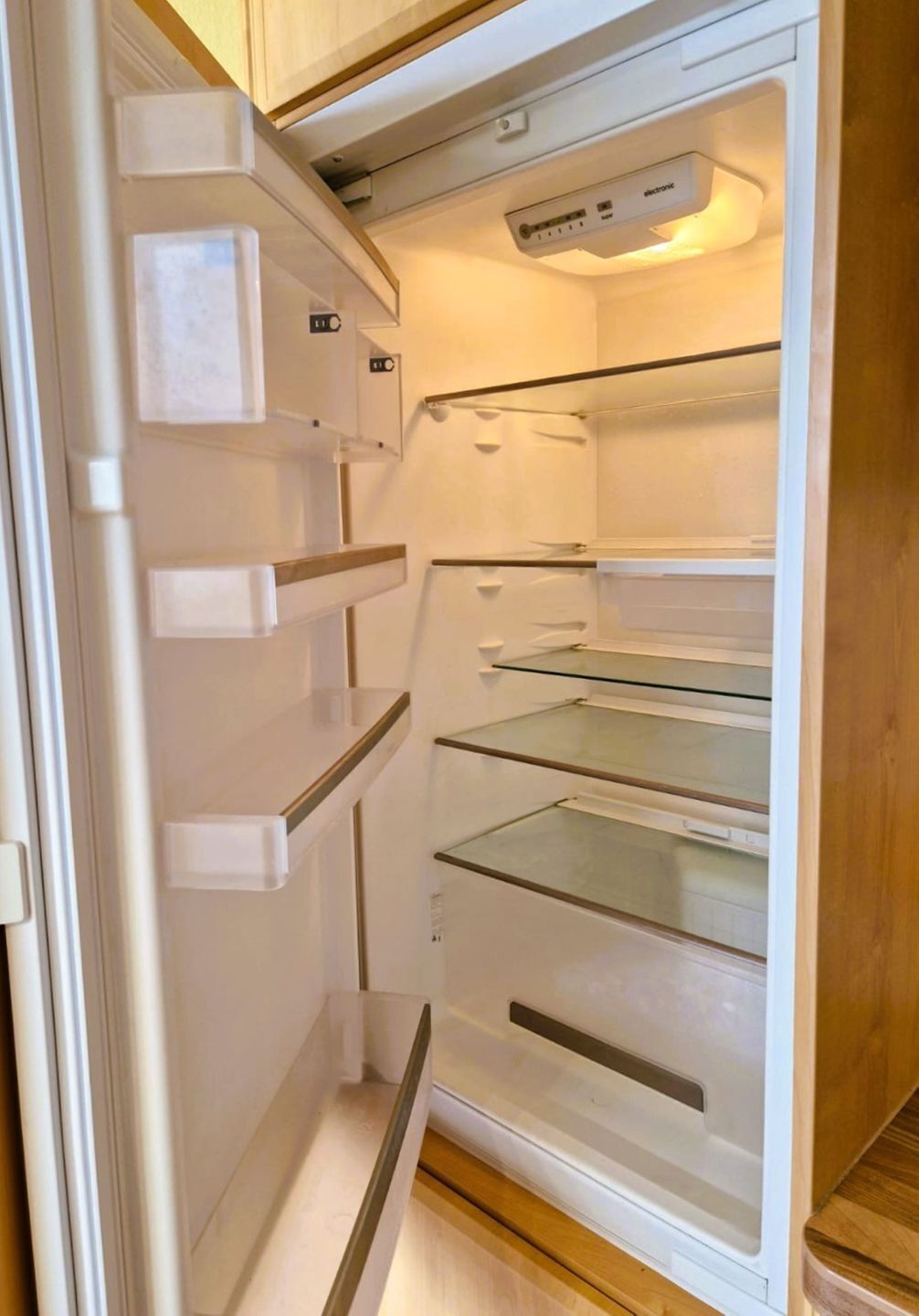 An open refrigerator with multiple shelves and a freezer compartment.