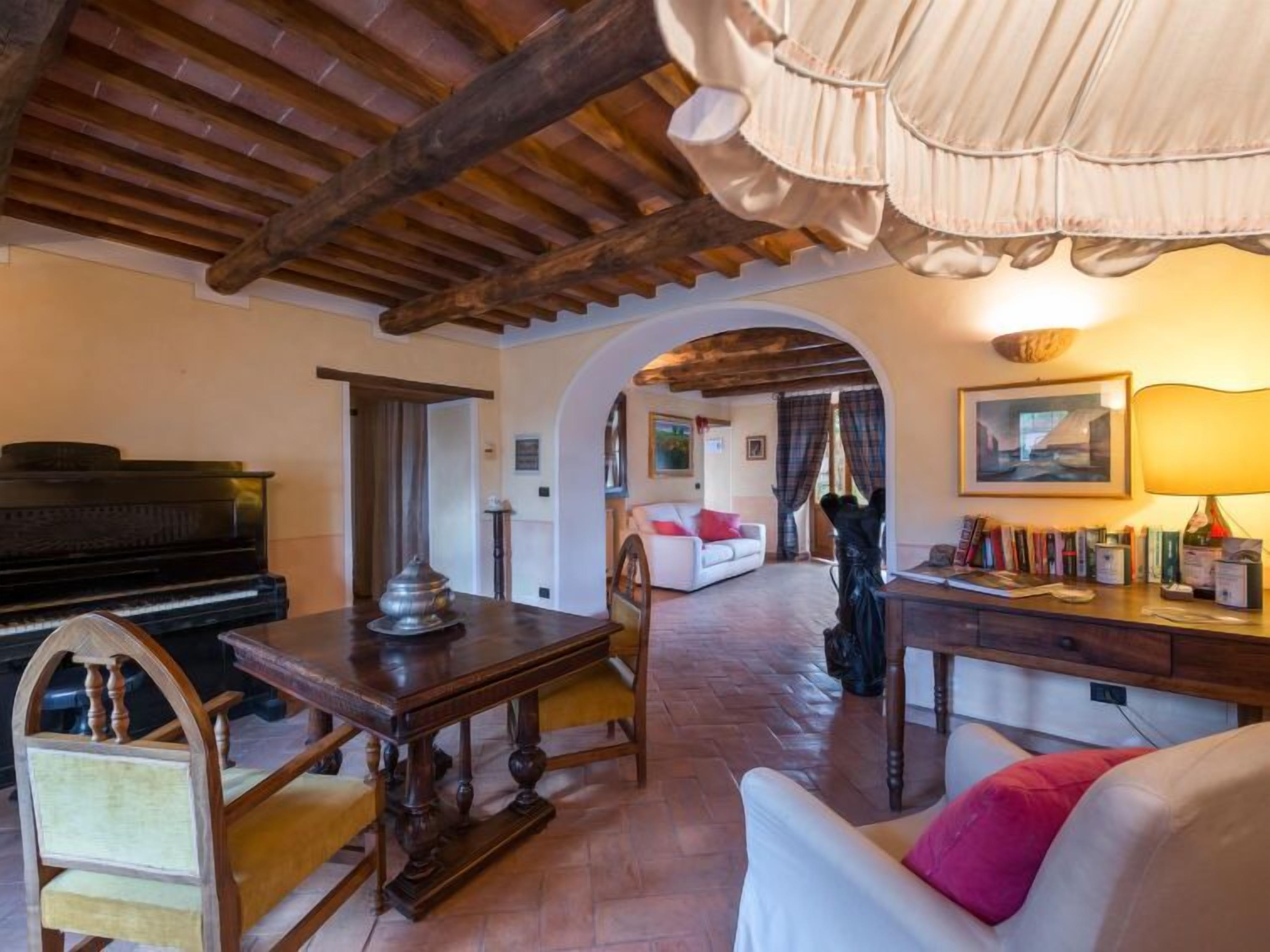 A cozy living room with a piano, a wooden table, and a sofa.
