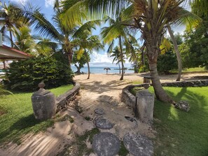 Un sendero que lleva a una playa con palmeras y vistas al océano.