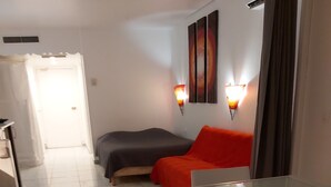 A hotel room with a bed, a dining table, and a sofa. - big unit in the most beautiful residence in Guadeloupe (saint-françois)