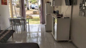 A hotel room with a bed, a dining table with chairs, a kitchenette, and a view of the outside. - big unit in the most beautiful residence in Guadeloupe (saint-françois)