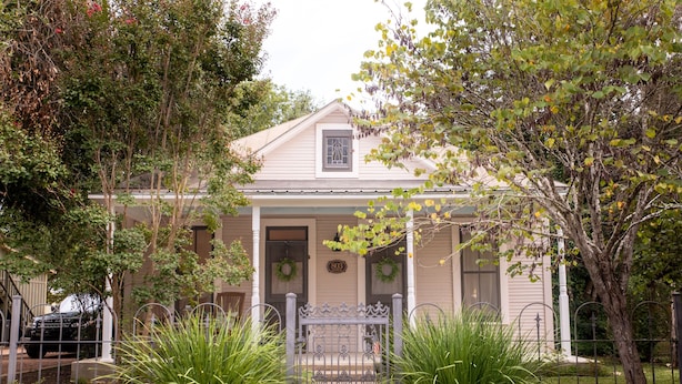 A two-story house with a front porch, a garage, and a driveway.