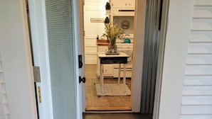 A wooden door with a doormat that reads "YAY YOU'RE HERE".