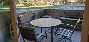 A wooden deck with a round table and four chairs, surrounded by a stone wall. - Hot Spot Ski Condo Free Beaver Creek Shuttle (Avon)