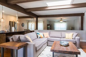 A modern living room with a sectional sofa, a wooden coffee table, and pendant lighting. - Kierland oasis, pool heater, spa, putting green (Scottsdale)