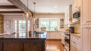 A modern kitchen with a central island, stainless steel appliances, and pendant lighting. - Kierland oasis, pool heater, spa, putting green (Scottsdale)