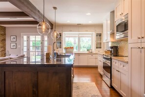 A modern kitchen with a central island, stainless steel appliances, and pendant lighting. - Kierland oasis, pool heater, spa, putting green (Scottsdale)