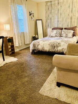 A bedroom with a large bed, a chair, a small table, and a mirror. - Get Away Sanctuary in Stone Mountain Mins from ATL (Stone Mountain)