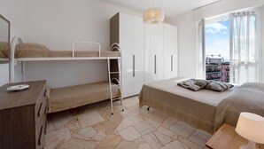 Una habitación con literas, escritorio, armario y vista a la ciudad.