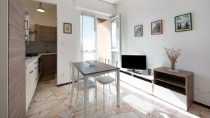 Una cocina moderna con una mesa de comedor, sillas y un televisor.