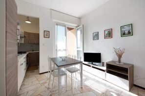 Una cucina moderna con un tavolo da pranzo, sedie e una televisione.