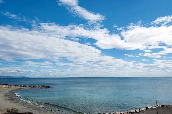 Vista costera con cielo despejado, mar tranquilo y costa rocosa.