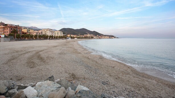 A beach with pebbles, a clear sky, and buildings in the background. - Vacation Apartment Trilocale Recagno nuovo near the Beach with A/C (Varazze)
