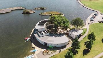 An aerial view of a circular building with a central courtyard, surrounded by water and small islands.