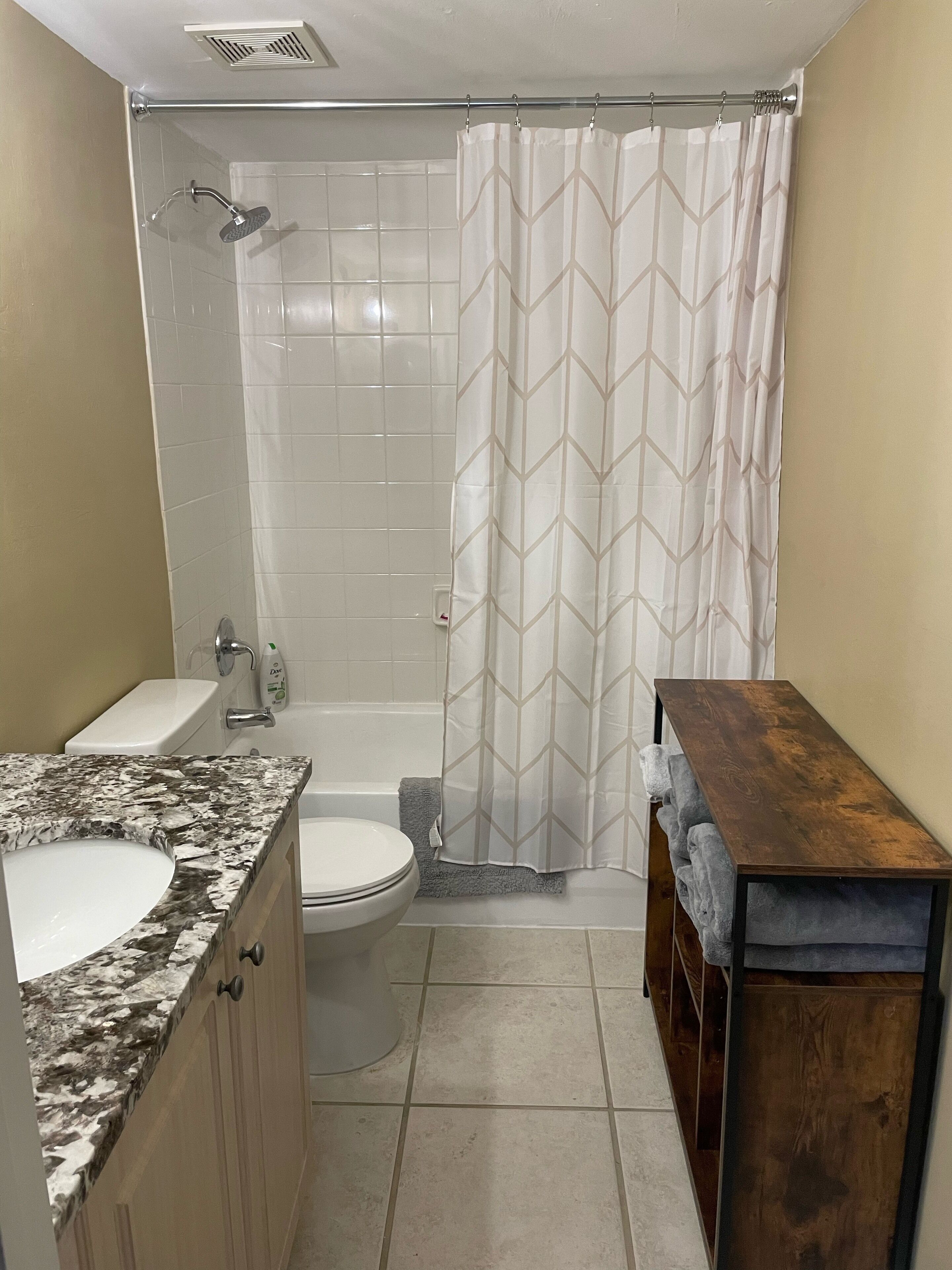 A bathroom with a shower, toilet, and sink.