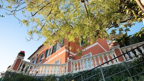 A building with a balcony, a staircase, and a railing.