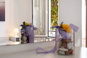 Une chambre à coucher avec un lit, une table de chevet, une lampe et une fenêtre donnant sur un paysage verdoyant.