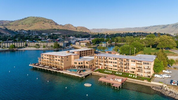 Un hotel frente al agua con varias edificaciones, un muelle y una zona de piscina.