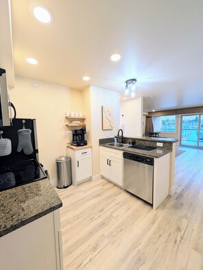A modern kitchen with granite countertops, stainless steel appliances, and a view of the outdoors. - Waterfront View, Pool, Hot Tub, Steps To Downtown (Chelan)