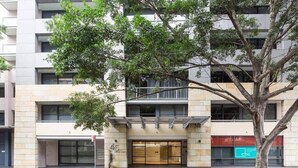 Un immeuble à plusieurs étages, avec un arbre devant, une entrée au niveau du sol et un panneau CTIC bien visible.