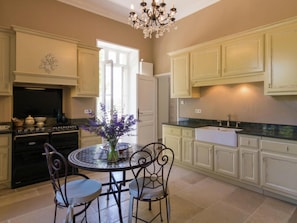 Enjoy cooking in this well-equipped kitchen with a central island, black stove, sink, and refrigerator.