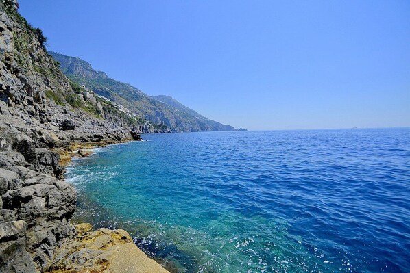 A coastal landscape with rocky cliffs and clear blue sea. - Casa Giasone: A characteristic and welcoming apartment that is part of a villa built sheer above the sea and with direct access to the sea, with Free WI-FI. (Praiano)