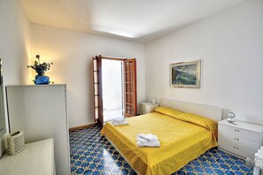 A hotel room with a bed, a nightstand, a desk, and a chair. - Casa Giasone: A characteristic and welcoming apartment that is part of a villa built sheer above the sea and with direct access to the sea, with Free WI-FI. (Praiano)
