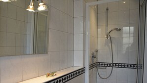 A bathroom with a shower, a sink, and a mirror.
