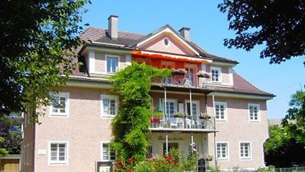 A two-story building with a balcony on the upper floor.