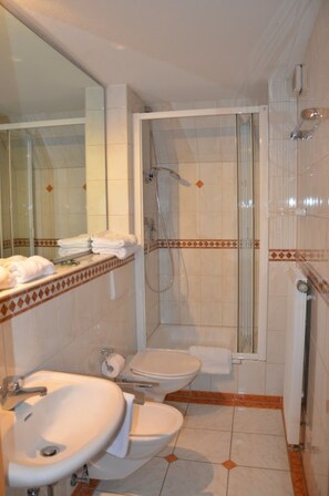 Een douche, een haardroger, een bidet, handdoeken