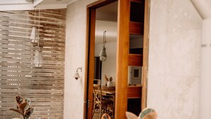 A modern house with a wooden deck, a wooden door, and a dining area visible through the door. - Gorgeous 5 bedroom beach house. Dog/Kid Friendly. (Marcoola)