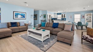 A living room with a sofa set, a coffee table, and a dining area with chairs and a table.