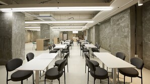 A conference room with white tables and chairs, a podium, and a long table in the center. - Bonathree Hotel (Busan)