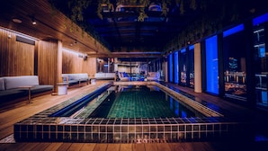 A modern indoor pool area with wooden flooring, seating, and large windows. - The Rockefeller Hotel by NEWMARK (Cape Town)