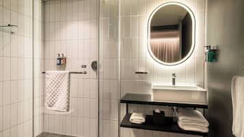 Un bagno moderno con doccia vetrata, un mobile lavabo con specchio e un porta asciugamani.