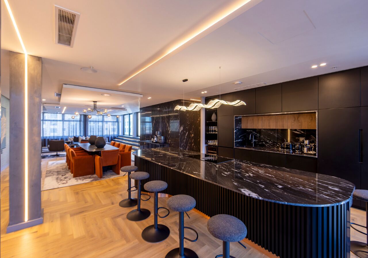 Una cocina moderna con encimera de mármol y taburetes de bar.