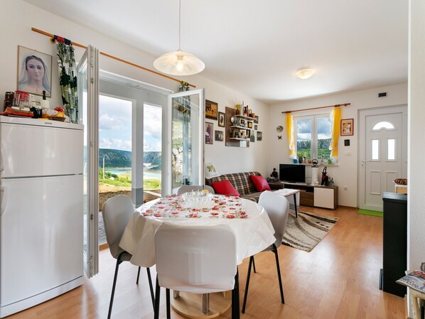 Enjoy a serene mountain view from the spacious living area with a dining table and comfortable seating.