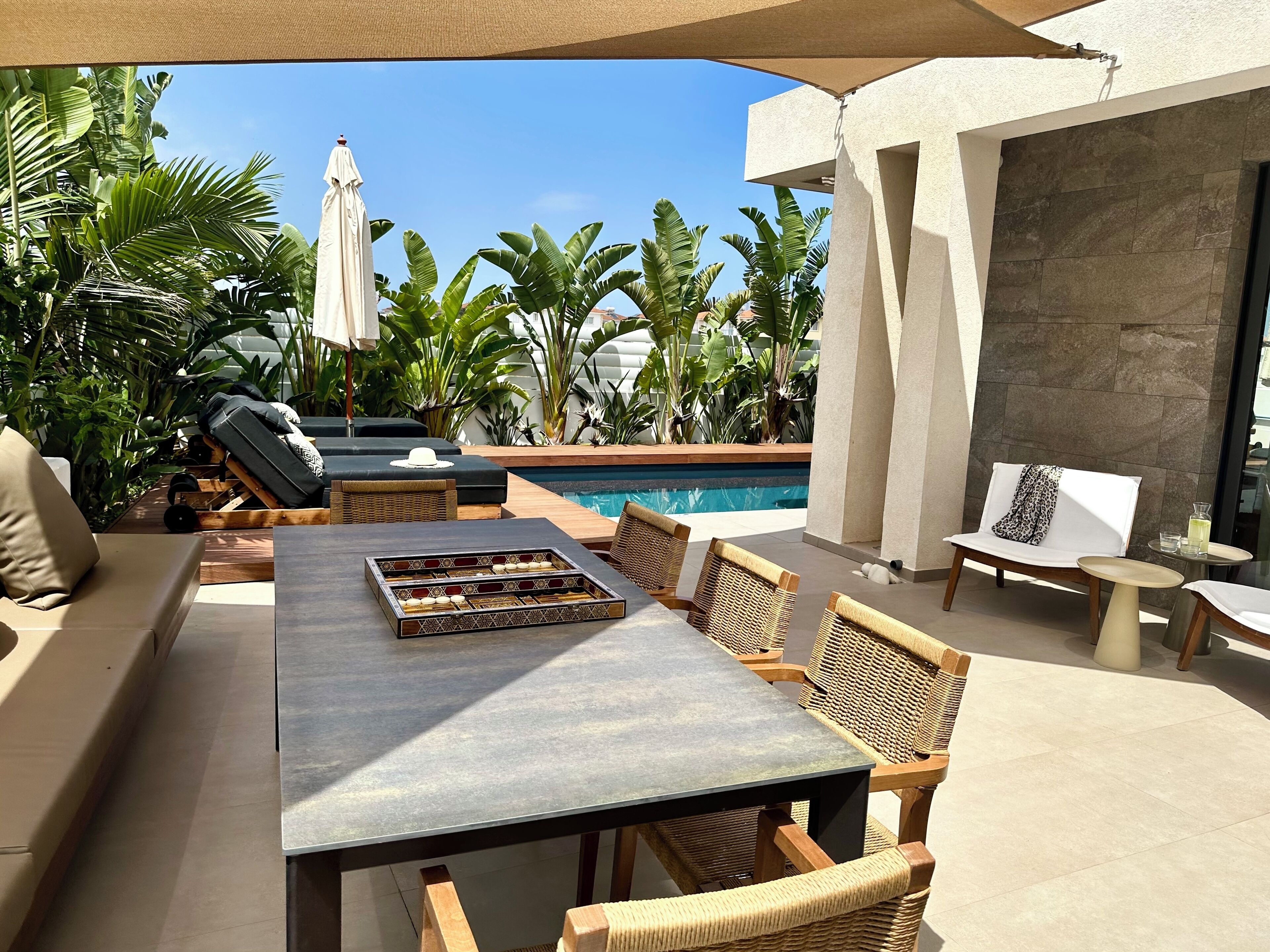 An outdoor seating area with a pool, lounge chairs, and a table with a tray.
