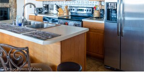 A kitchen with wooden cabinets, a stainless steel refrigerator, a microwave, an oven, and a sink. - Ranch Home w/ Rolling Hill Views & Hot Tub (Harman)
