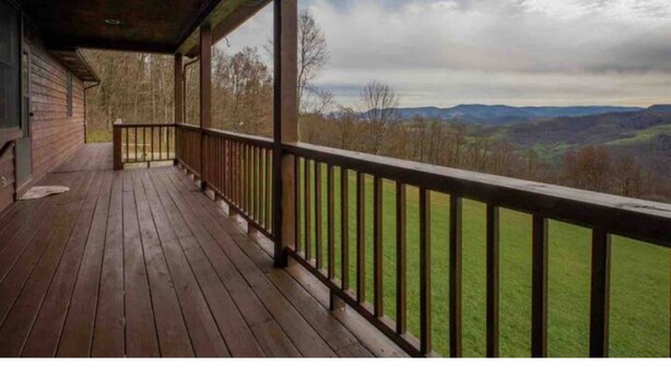 A wooden deck with a railing overlooking a mountainous landscape. - Ranch Home w/ Rolling Hill Views & Hot Tub (Harman)