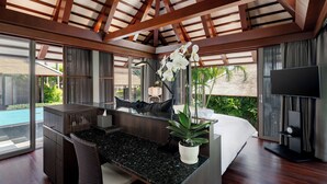 A modern living room with a large island, a flat-screen TV, and a ceiling fan. - Villa Akatsuki (Koh Samui)