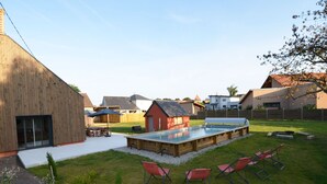 A backyard with a swimming pool, outdoor seating, and a wooden deck. - Spacious 5-Bedroom House with Private Pool, Games Room, and Terrace in Changé (Changé)