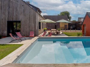 A rectangular swimming pool with a wooden deck, surrounded by lounge chairs and umbrellas. - Spacious 5-Bedroom House with Private Pool, Games Room, and Terrace in Changé (Changé)