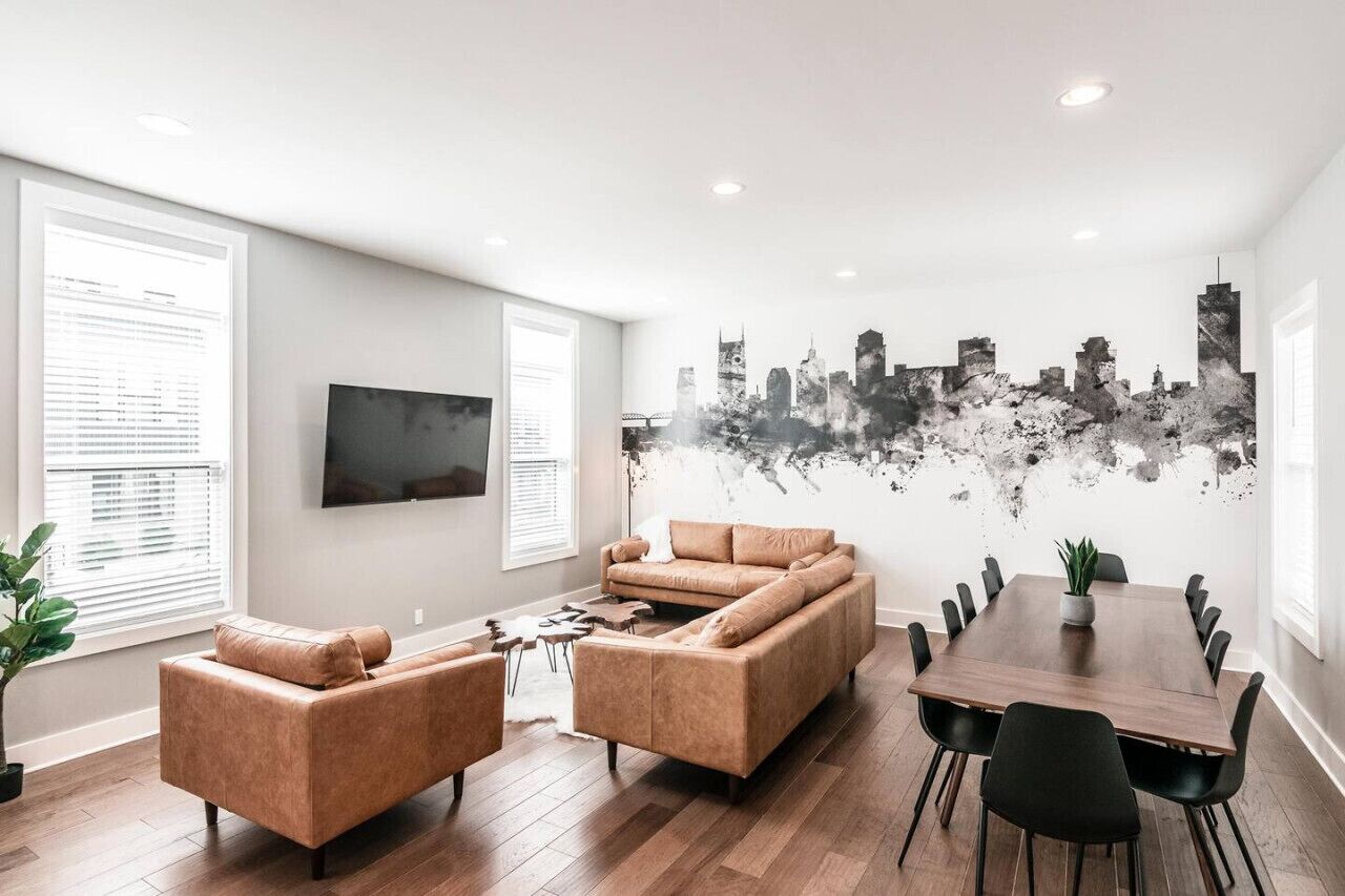 En moderne stue med sofa, sofabord og spisebord med stole.